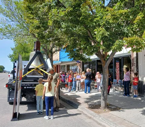 Fourth graders line up on Main Street to ring the bell