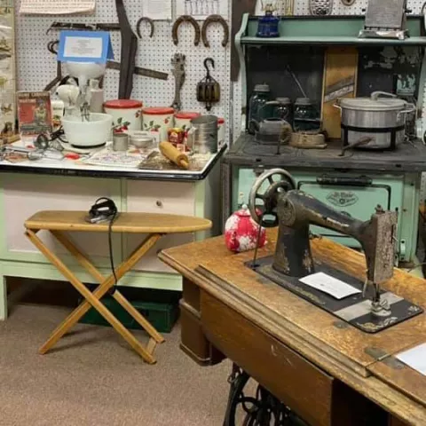 An everyday-living display: a kitchen cabinet, stove and treadle sewing machine